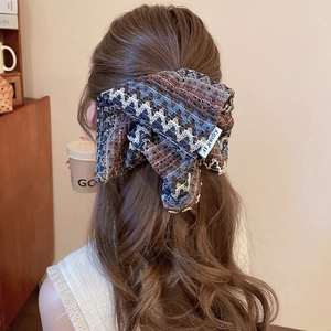 Détail d'un bandeau en tricot vintage avec des motifs de crochet géométriques colorés