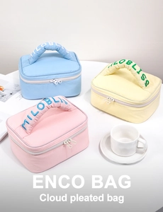 Detail of macaron cloud pleated makeup bags with embroidered handles and dual zippers