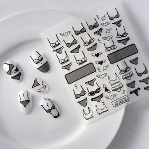 Detailed macro view of 5D embossed black lace underwear nail stickers on white tips