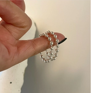 Close-up of minimalist 925 silver beaded rings styled in a stacking set on fingers
