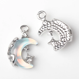 Macro view of silver crescent moon and star pendant with opal inlay and clear zircons