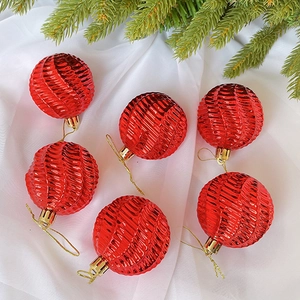 Detailansicht von 6 roten Spiral-Weihnachtskugeln auf weißem Seidenstoff-Hintergrund