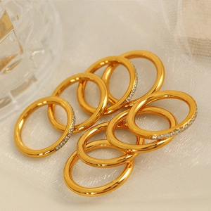 Set of eight gold-plated minimalist stacking rings featuring delicate zircon stone accents