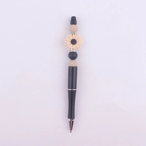 Detail of beaded pen featuring beige sunflower silicone charms and rhinestone spacers