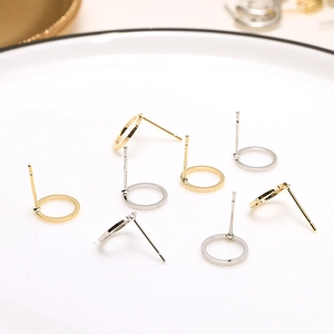 Minimalist gold and silver 18k plated C-shaped hoop earrings on white ceramic tray