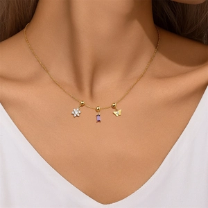 Detail of adjustable gold necklace featuring purple zircon, crystal flower and butterfly