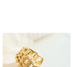 Macro shot of wide gold hollow chain-link ring featuring modern textured interlocking design