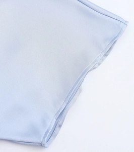 Macro shot of light blue satin dress fabric texture and fine stitching craftsmanship