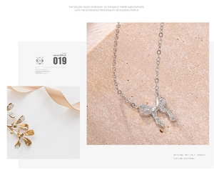 Detailed macro view of a silver bow pendant necklace with sparkling pavé crystals