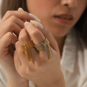 Close-up of beaded tassel rings in gold and silver finish with elegant bow design