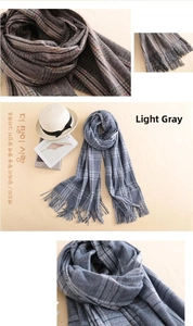 Detail of light grey plaid cashmere scarf with soft fringe edges for winter warmth