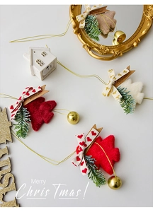 Close-up of plush Christmas tree ornaments with golden bells and heart-print ribbons