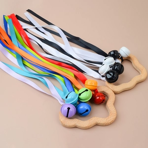 Detailed view of wooden sensory rings with rainbow ribbons and colorful metal bells