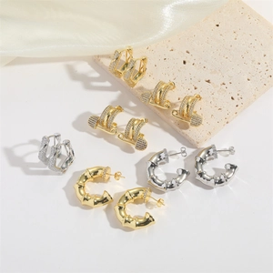 Minimalist gold and silver geometric earrings with zircon pavé on a textured background