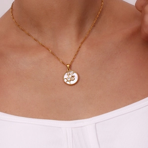 Close-up of 18K gold plated celestial sun and moon pendant necklace on a model