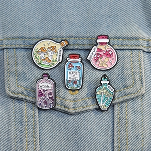 Detailed close-up of colorful mushroom enamel pins on a light blue denim jacket pocket