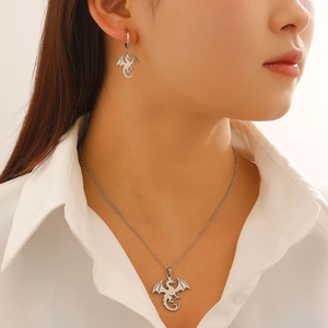 Vue détaillée d'un collier pendentif dragon argenté et boucle d'oreille style gothique