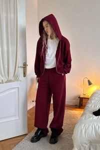 Detail of burgundy lounge set featuring zip-up cropped hoodie and wide-leg sweatpants