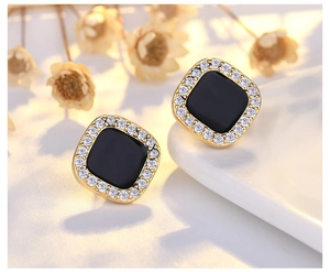 Macro shot of French vintage square chain earrings with black enamel and sparkling crystals