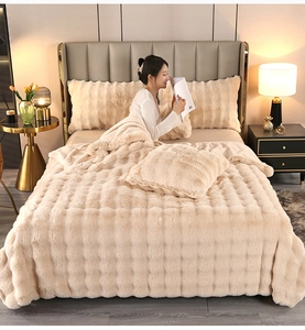 Close-up of beige faux fur blanket featuring embossed 3D grid texture and plush warmth