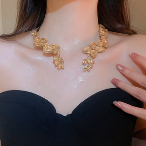 Close-up of champagne crystal leaf collar necklace worn on collarbone with gold setting