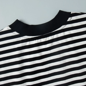 Dettaglio dello scollo a coste nero su una maglia casual a righe in misto cotone