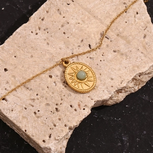 Macro view of 18K gold plated oval sun pendant featuring a green natural stone inlay