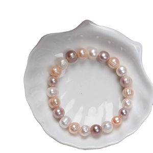 Handmade natural freshwater pearl bracelet with multi-color beads in a white shell dish