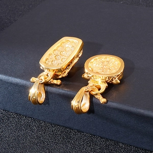 Hip hop style gold owl pendants in round and rectangular shapes on black surface