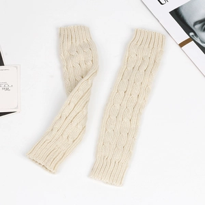 Close-up of cream knit arm warmers featuring a detailed cable stitch pattern texture