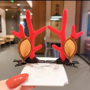 Detail of red reindeer antler hair clips with ears on white card for Christmas