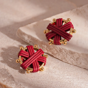 Detailed macro view of vintage red faux leather woven earrings with golden metal base