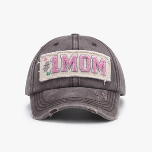 Close-up of distressed charcoal grey baseball cap with pink #1MOM towel embroidery detail