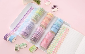 Detail of plaid washi tape sets in soft colors arranged on a white tray for DIY journals