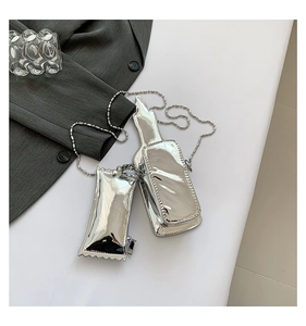 Detailed view of silver bottle and candy-shaped metallic bags with chain straps
