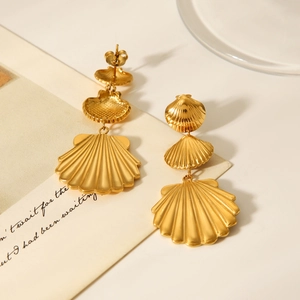 18K gold plated stainless steel triple shell drop earrings on a minimalist background