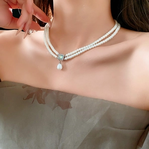 Close-up of French style double-layer pearl necklace with blue square stone and drop pearl