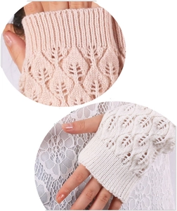 Close-up of pink and white knitted fingerless gloves with delicate leaf cutout patterns