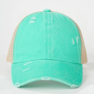 Detail showing distressed cotton fabric and mesh back of the mint green trucker hat