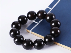 Macro view of polished dark green sandalwood beads with natural wood grain texture