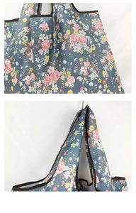 Macro detail of large floral shopping bag showing fabric pattern and reinforced handle seams