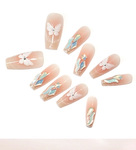 Close-up of pink gradient press-on nails with 3D butterflies and aurora rhinestones