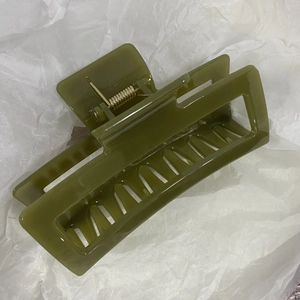 Detailed view of extra-large olive green rectangle hollow hair claw clip with gold spring
