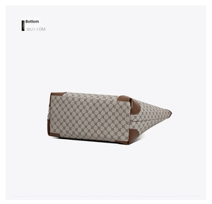 Detail of the large tote bag bottom with grey logo canvas and brown leather corners