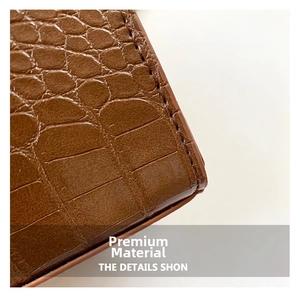 Vue macro du simili cuir marron avec texture crocodile et coutures de qualité