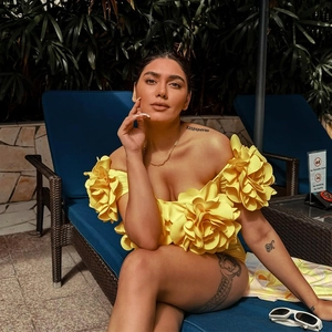 Detailed view of 3D floral accents on a vibrant yellow off-shoulder swimsuit