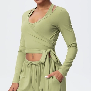 Detail view of avocado green v-neck gym top with stylish cross-tie waist and soft texture