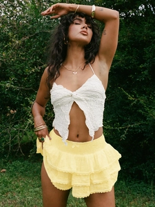 Détail de la broderie en dentelle florale et de l'ourlet à volants d'une mini-jupe jaune