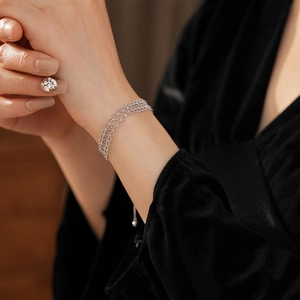 Detail of adjustable silver hollow lace bracelet on wrist with fine woven metal texture