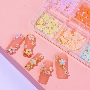 Macro view of 3D resin camellia flowers and pearls on matte pink press-on nails
